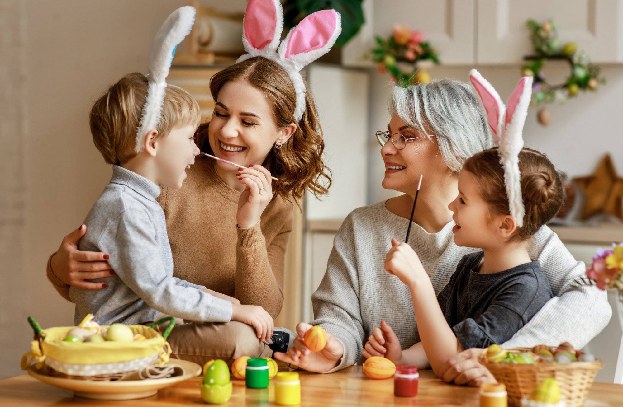 Happy easter! family mother, grandmother and children paint eggs for holiday