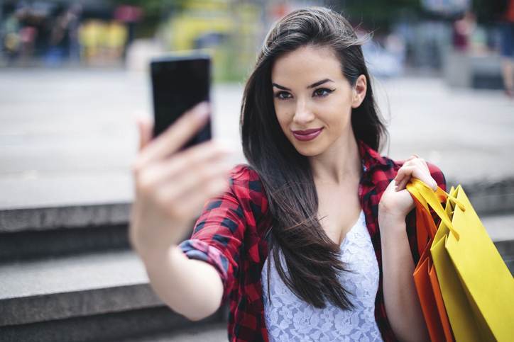 Beautiful girl shoping in the city and taking a selfie